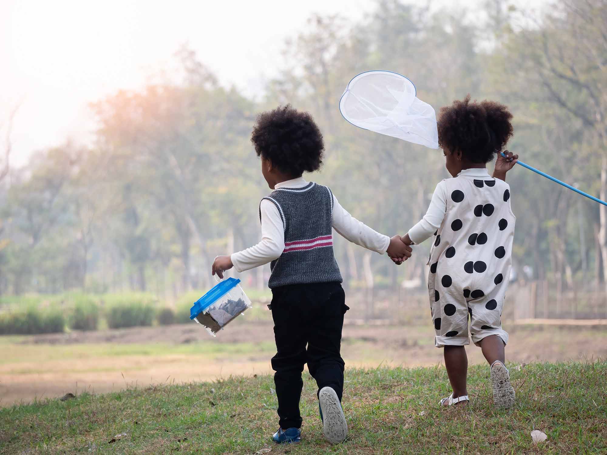 Two kids running with butterfly net